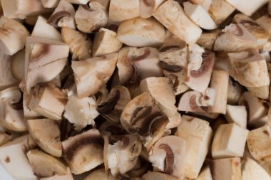 Dilimlenmiş ve doğranmış şampiyon mantarları yakından çek. Dünyanın farklı mutfaklarında bulunan popüler bir bileşen. Arkaplan