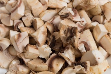 Dilimlenmiş ve doğranmış şampiyon mantarları yakından çek. Dünyanın farklı mutfaklarında bulunan popüler bir bileşen. Arkaplan