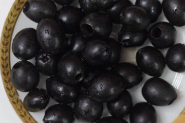 Büyük, güzel, siyah Yunan zeytinleri. Bulanık arkaplan üzerine seçmeli odak.