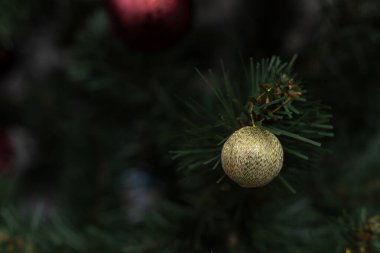 Yapay bir ağaçtaki altın top. Dekor elemanı. Bulanık arkaplan üzerine seçmeli odak.