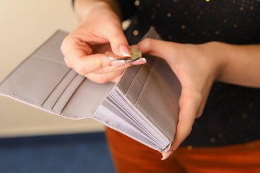 Kadınların elleri onları cüzdanından çıkarırken bozuk paraları sayar. Bulanık ev duvarı arka planına seçmeli odaklan. Aile bütçesi kavramı