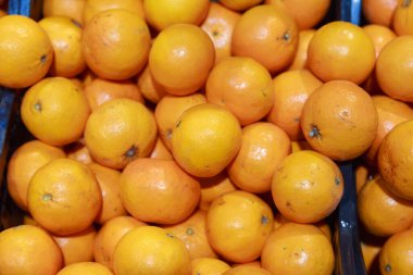 Tezgahta büyük mandalinalar var. Markette ya da süpermarkette taze meyve ve sebze satan bir mağaza. Arkaplan