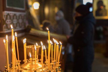 19 Ocak 2021 Balti Moldova dini vaftiz bayramı kilisede. İllüstrasyon başyazısı. Kilisenin karanlığında mum ışığında dua ediyorlar..