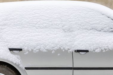 Karla kaplı bir araba. Şehirde kış mevsimi. Soyut arkaplan.