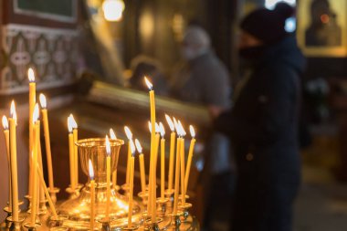 19 Ocak 2021 Balti Moldova dini vaftiz bayramı kilisede. İllüstrasyon başyazısı. Kilisenin karanlığında mum ışığında dua ediyorlar..