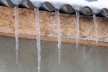 Binanın çatısında buz saçakları var. Metin veya yazıtlar için boşluk kopyala. Arkaplan