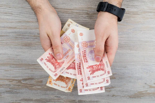 Moldova parasıyla çalışan bir adam. MDL Moldova Lei. Masraflar ve gelir temasının soyut bir özeti. Bütçe