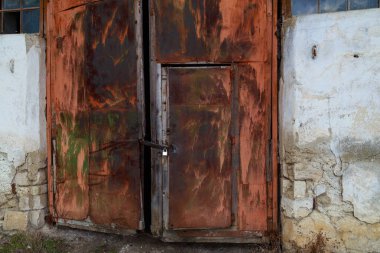 Terk edilmiş eski bir sanayi binası ya da hangarın kapıları. Arkaplan