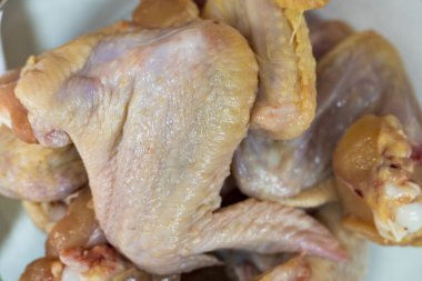 Tabakta çiğ tavuk kanadı. Evde yemek yapmak için gerekli malzemeler. Seçici odaklanma. Arkaplan