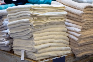 Bir rafta yığınla havlu var. Kişisel hijyen için tekstil ürünleri sergisi. Arkaplan
