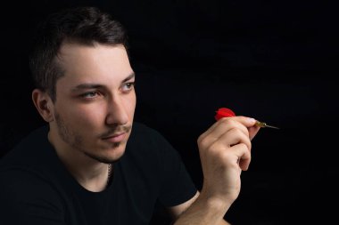 Siyah elbiseli, siyah arka planda kırmızı dartlı yakışıklı bir adam. Hedef belirleme kavramı