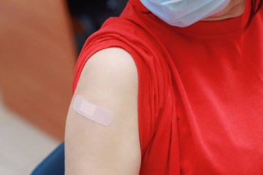 Coronavirus aşısından sonra hastaların omzunda mühürlü alçı var. Gerçek prosedür ve durum. Seçici odak