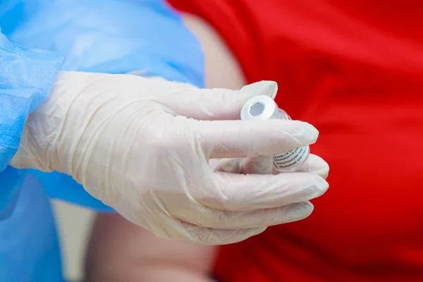 A nurse demonstrates to the patient the expiration date of the coronavirus vaccine. Background with copy space for text.