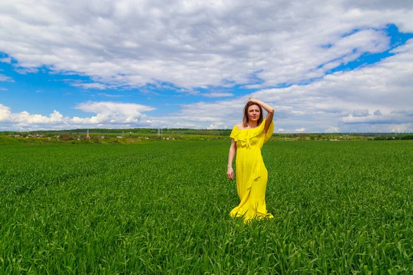 Yeşil Bir Tarlada Sarı Elbiseli Genç Bir Kadın Gülme Havası — Stok fotoğraf