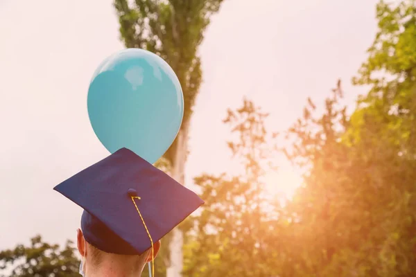 The back of a graduate wearing a square, quadrangular academic cap. Graduation day.