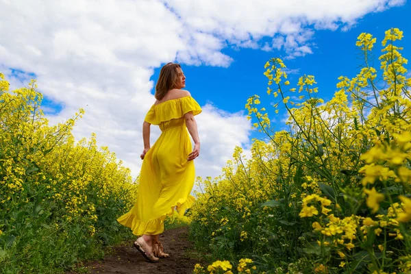 Sarı Elbiseli Parlak Sarı Arka Planda Çiçek Açan Kolza Tohumu — Stok fotoğraf