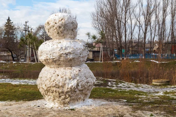 溶かした牧草地に巨大な春の雪だるま 文字やテキストのためのコピースペースを持つ背景 — ストック写真