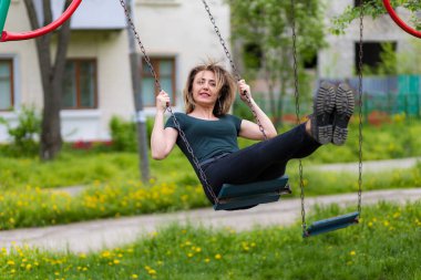 Parkta salıncakta sallanan genç bir kadın. Özgürlük ve mutluluk kavramı