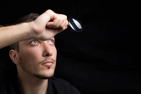 Joven Hombre Guapo Una Lupa Sobre Fondo Negro Tono Bajo — Foto de Stock