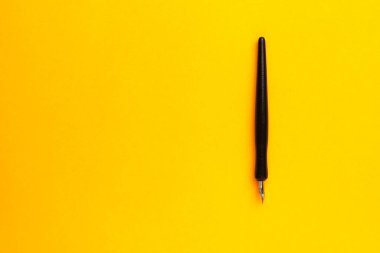 Metin veya yazıtlar için kopyalama alanı olan sarı bir arkaplan üzerindeki kalem.