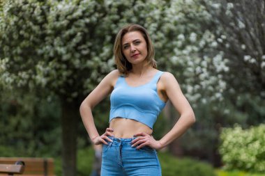 Otuz yaşından büyük mutlu bir kadının portresi çiçek açan ağaçların bulanık arka planında. Metin için kopyalama alanı