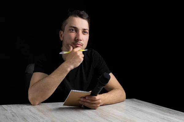 Homem Bonito Jovem Roupas Pretas Com Microfone Notebook Caneta Fundo — Fotografia de Stock