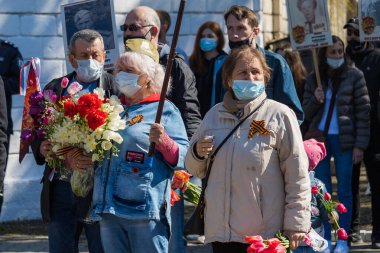 Tören alayındaki insanlar. İkinci Dünya Savaşı anısına zafer yürüyüşü. 9 Mayıs 2021 Balti Moldova. İllüstrasyon Editörü
