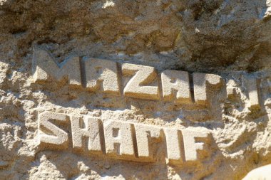 Afgan dağına veya taşına kazınmış bir yazı: MAZAR SHARIF. Afganistan 'daki en büyük dördüncü şehir. Eyaletin başkenti Balkh 'tır. Arkaplan