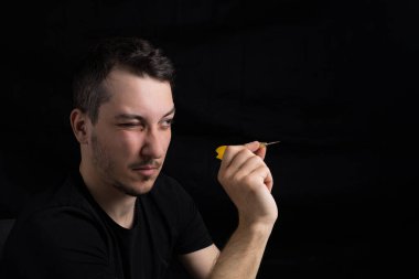 Siyah elbiseli, siyah arka planda kırmızı dartlı yakışıklı bir adam. Hedef belirleme kavramı