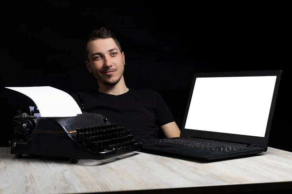 Mladý Pohledný Muž Uprostřed Mezi Psacím Strojem Laptopem Černém Pozadí — Stock fotografie