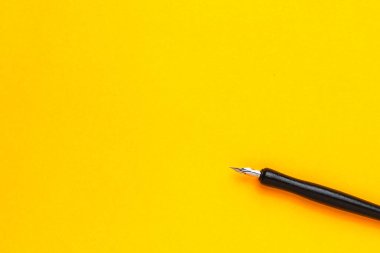 Metin veya yazıtlar için kopyalama alanı olan sarı bir arkaplan üzerindeki kalem.