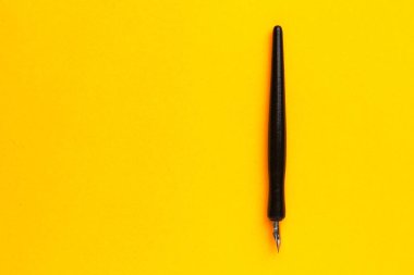 Metin veya yazıtlar için kopyalama alanı olan sarı bir arkaplan üzerindeki kalem.