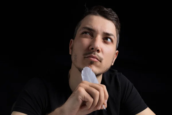 Young Handsome Man Black Clothes Goose Feather Looks Pensively Romantically — Stock Photo, Image