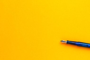 Metin veya yazıtlar için kopyalama alanı olan sarı bir arkaplan üzerindeki kalem.