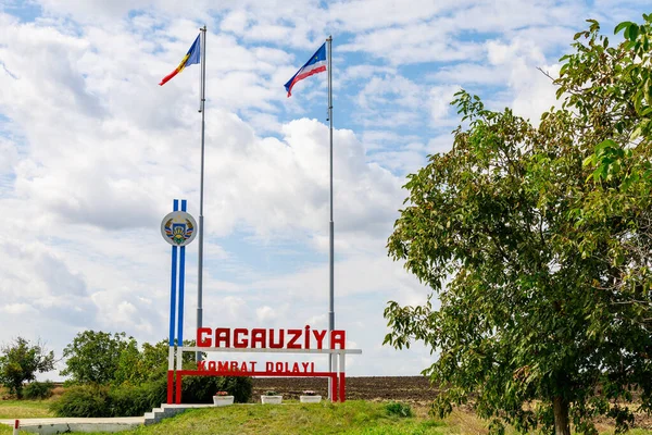 Gagauz dilindeki yazıt GAGAUZIA KOMRAT DISTRICT. Gagauzia 'ya hoş geldin Moldova. Moldova ve Gagauzia bayrakları. Arkaplan