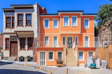 Colorful orange building in urban setting with decorative facade and clear blue sky. August 12, 2025 Istanbul Turkey.