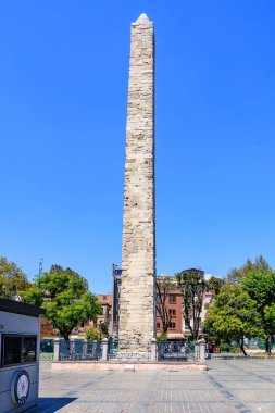 Ancient stone obelisk towering in sunny city landscape with clear blue sky. August 12, 2025 Istanbul Turkey.
