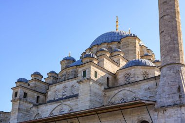 Architectural beauty of historic mosque under clear blue sky.