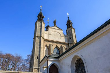 Historic gothic church architecture with twin towers against clear blue sky.