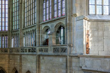 Historic cathedral interior with stained glass and stone architecture.