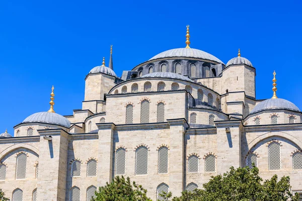 Architectural marvel: ottoman era mosque with domes and blue sky backdrop.