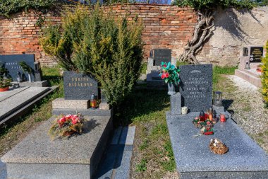 Serene cemetery with headstones and floral arrangements under clear sky.. March 22, 2025, Kutna Hora, Czech Republic.
