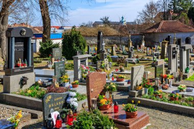 Colorful flower adorned cemetery with diverse headstones and serene atmosphere.. March 22, 2025, Kutna Hora, Czech Republic.