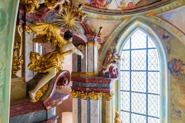 Ornate baroque church interior with decorative sculptures and stained glass window.. March 22, 2025, Kutna Hora, Czech Republic.