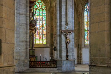 Gothic cathedral interior with crucifix and stained glass windows.. March 22, 2025, Kutna Hora, Czech Republic.