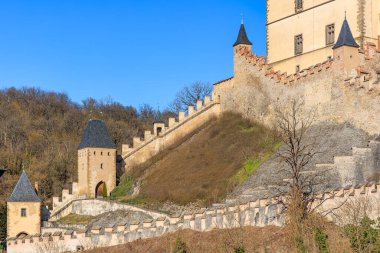 Temiz mavi gökyüzünün altında antik taş duvarları ve kuleleri olan tarihi ortaçağ kalesi.