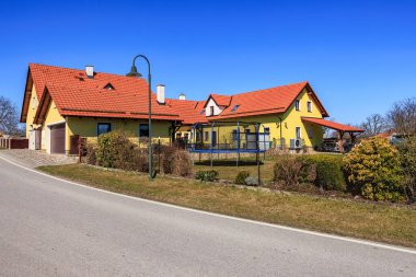 Parlak mahallede kırmızı çatıları ve trambolini olan güneşli banliyö evi..