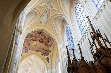 Gotik kilisenin içinde fresk, kemerli tavan, vitraylı pencereler ve tahta minber 22 Mart 2025, Kutna Hora, Çek Cumhuriyeti.