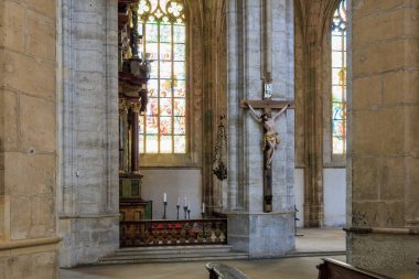 Gotik kilisenin içinde haç ve vitraylı pencereler 22 Mart 2025, Kutna Hora, Çek Cumhuriyeti.