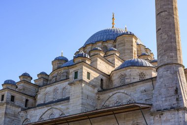 Gökyüzüne karşı tarihi minare ve cami kubbesi.